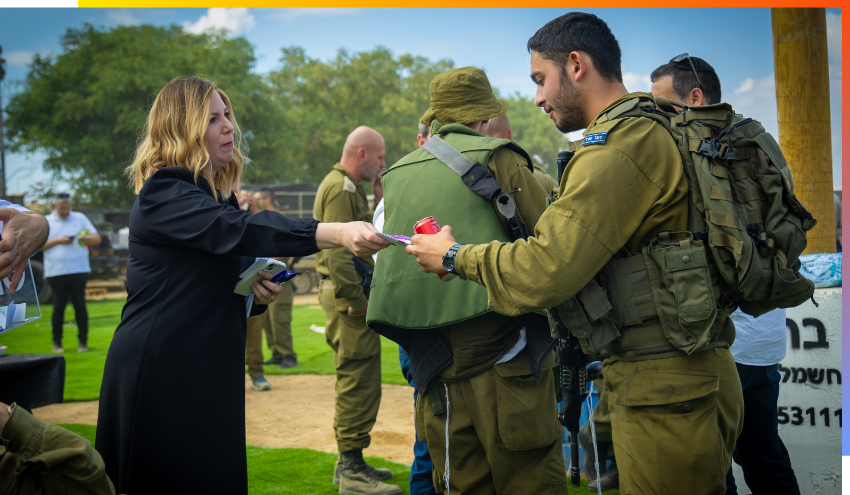Jamie Geller hands a soldier a drink and a note prior to the soldier's deployment to Gaza in October
