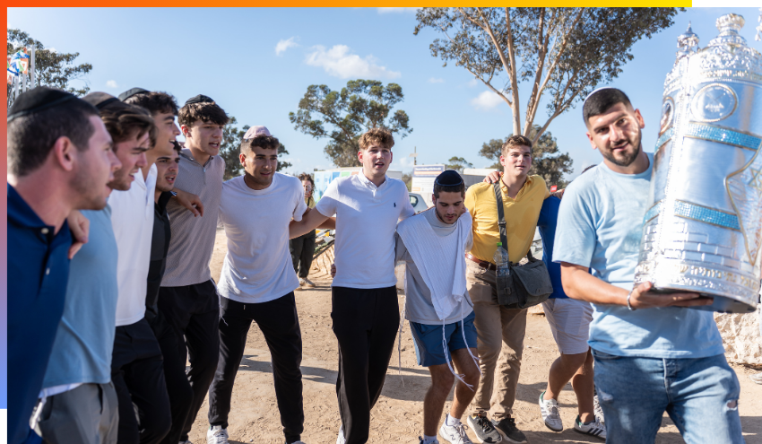 Aish students dancing with a Torah