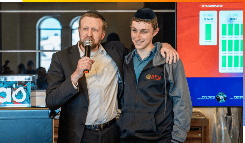 Educational Director at EFG@Aish, Rabbi Nachman Elsant, puts his arm around Ezra Solomon at the All in for Aish fundraising campaign HQ.