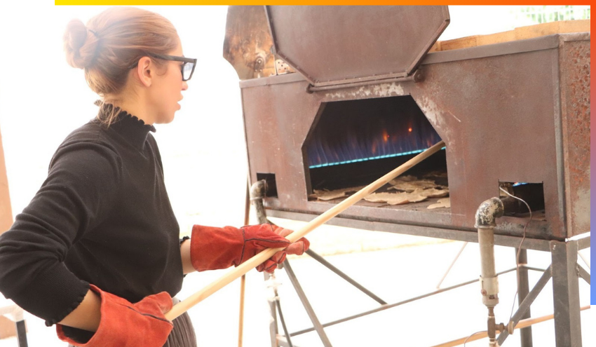 One of the students from Aish puts a freshly made Matza into an oven.