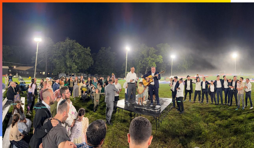 Yaakov Gade and Rabbi Motti Miller singing and playing guitar at a musical Havdalah after Rosh HaShanah
