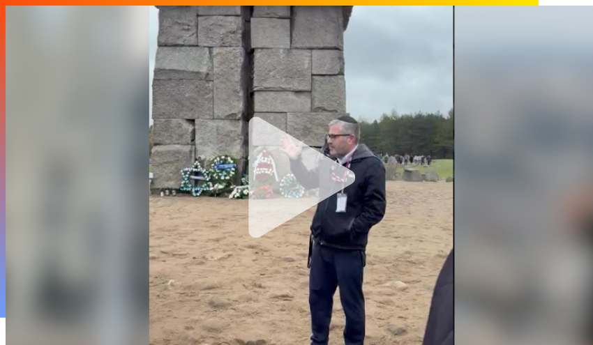 Rabbi Burg addressing the group in front of the stone memorial at Treblinka